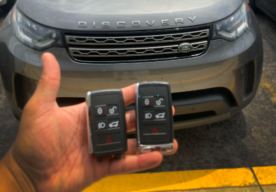Land Rover Discovery keys in front of car.
