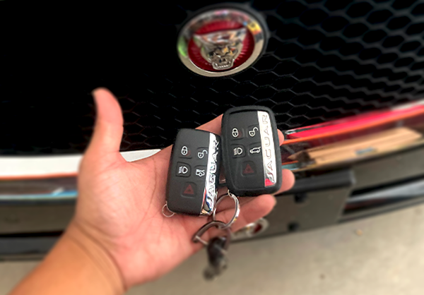 Image of Jaguar keys in front of red logo.